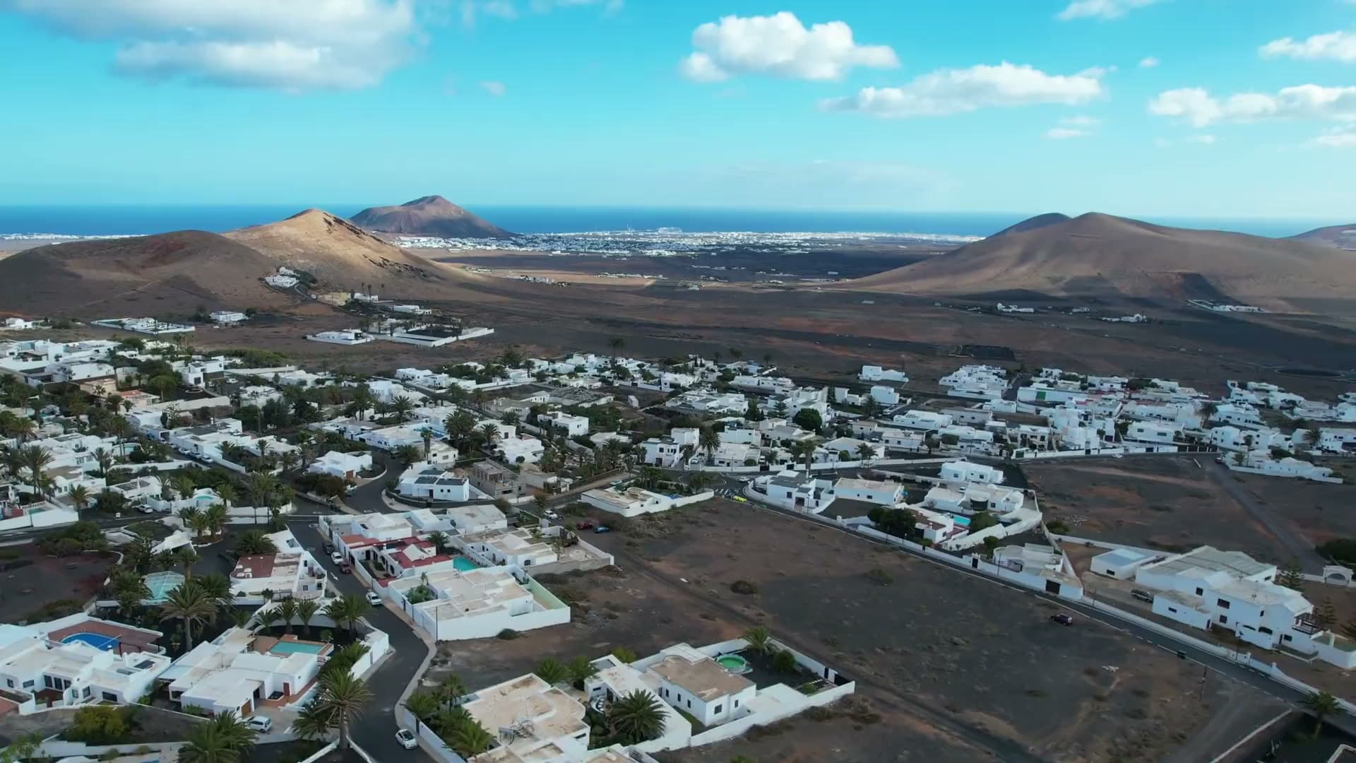 Vista aérea de un pueblo blanco entre volcanes en Lanzarote